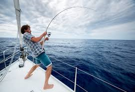 Man fighting with a large fish on a fishing pole