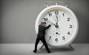 Man trying to pull back the hands of a clock
